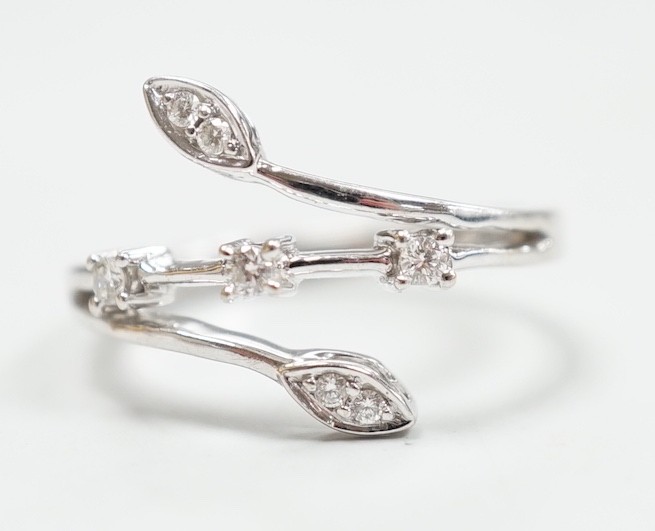 A modern 18k white metal and seven stone diamond chip set petal ring, size L, gross weight 3.3 grams.